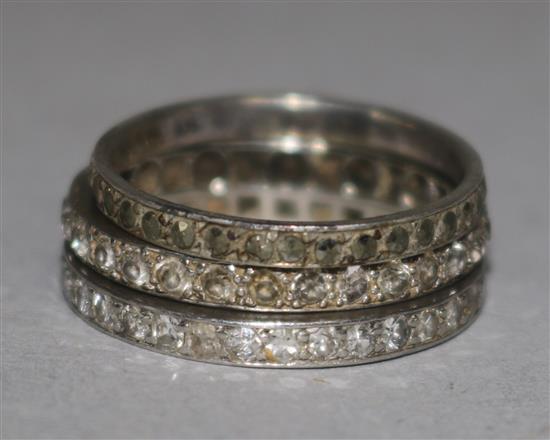 A diamond and platinum eternity ring and two other eternity rings